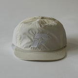 Creme cap with a logo on a white background